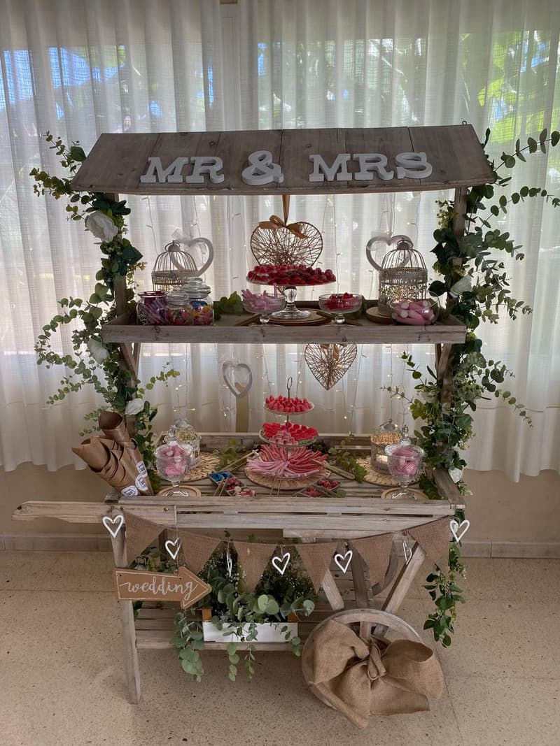 Candy bar «Mr & Mrs» de Empalagoso para una boda, con tarros de chuches, dónuts y guirnaldas